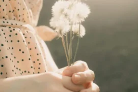 trauma-therapy-healing-massapequa Hands gently holding a dandelion, symbolizing healing and specialized trauma therapy in Massapequa.